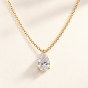 Collier Goutte Divine en moissanite avec chaîne dorée, sur fond ivoire