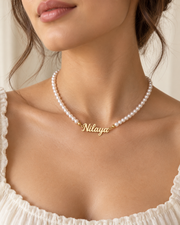 Collier Prénom Perlé doré avec perles blanches porté, exemple Nilaya